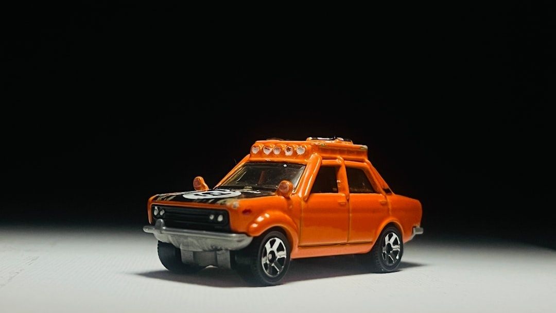 Oranges Spielzeugauto im Stil eines historischen Taxis auf dunklem Hintergrund
